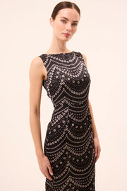 Woman wearing a black dress with a pattern on a beige background