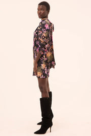 Person wearing a floral dress and black knee-high boots on a white background