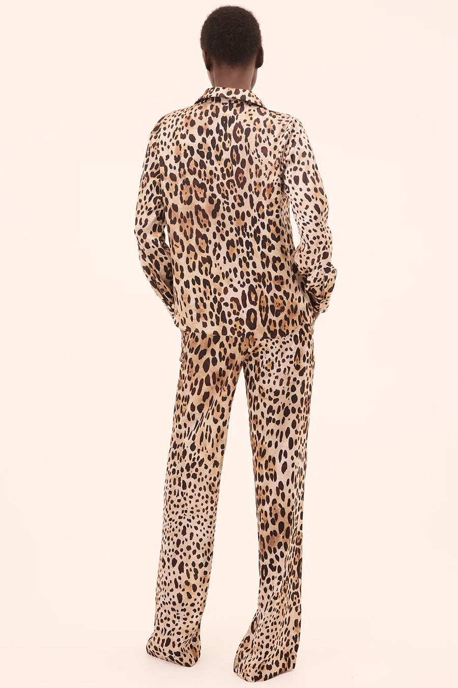 Back view of woman wearing a leopard print button down top