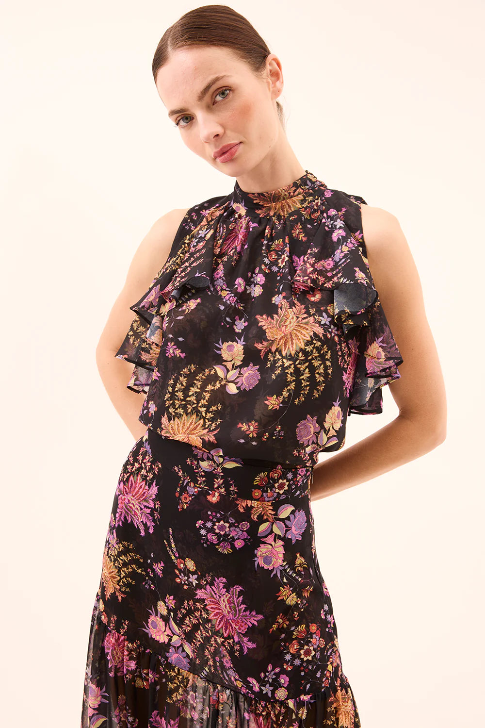 Woman wearing a sleevless floral top with ruffles