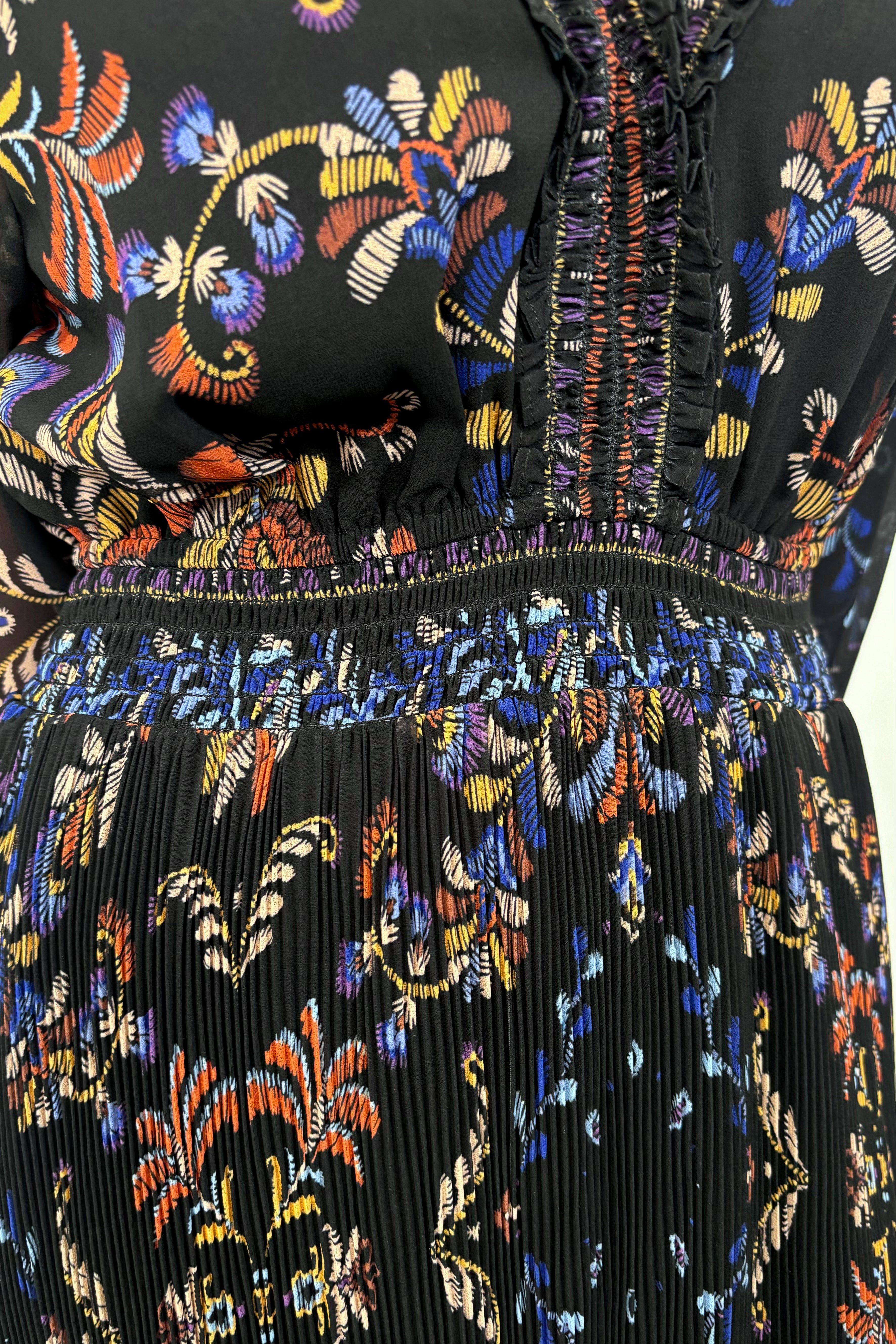 close up view of woman wearing a black v-neck maxi dress with a colourful pattern