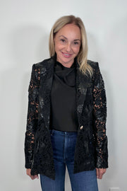 Front view of woman wearing a satin sleeveless top with a vegan leather lace blazer
