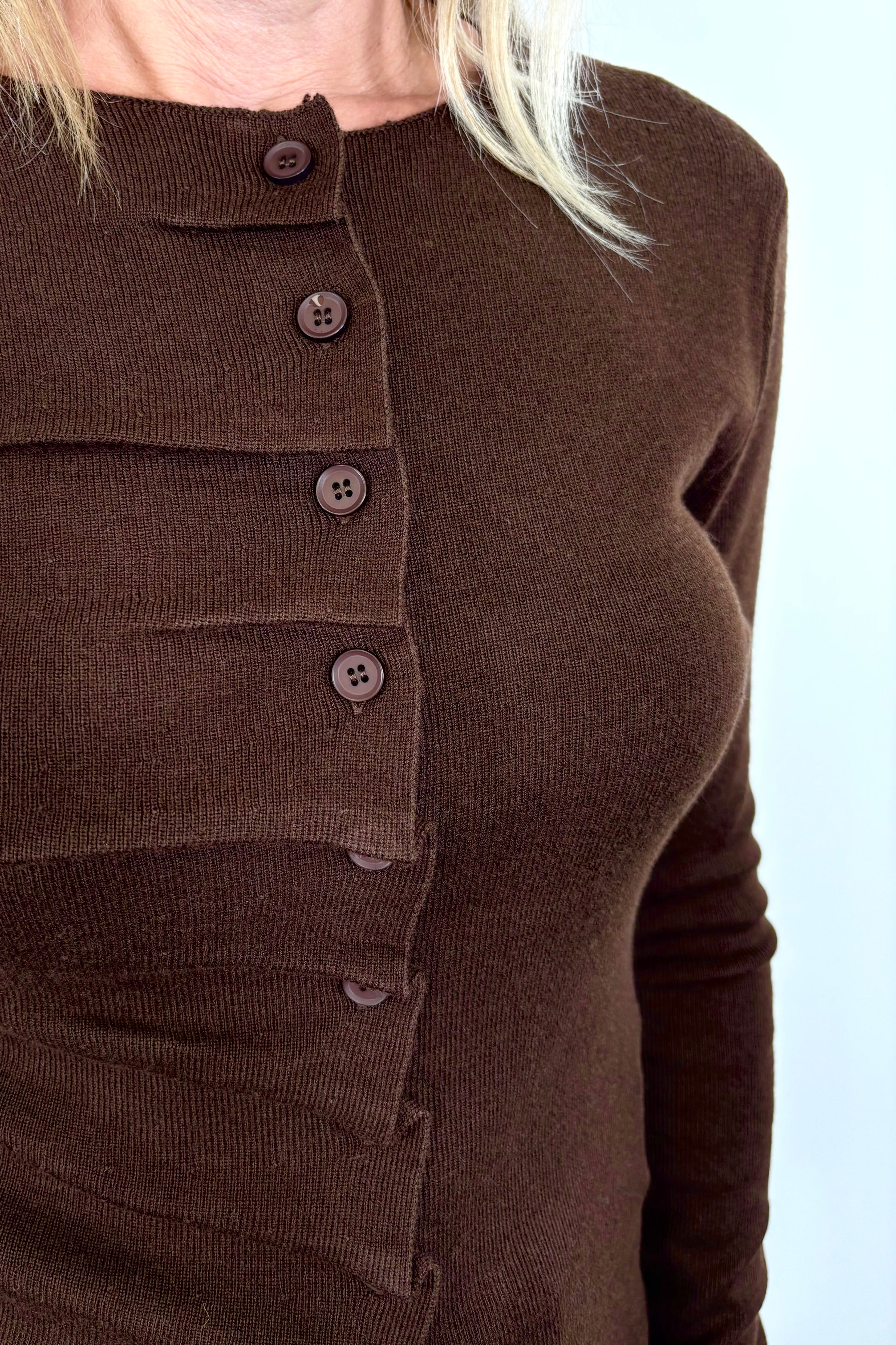 Front view zoom in of woman wearing a rouched in the buttons brown long sleeve knitted top