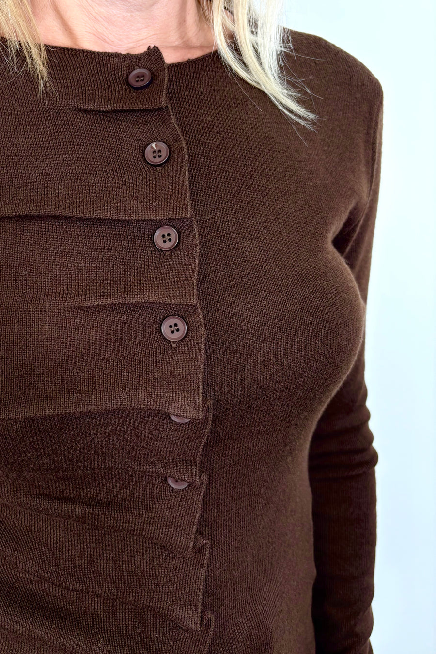 Front view zoom in of woman wearing a rouched in the buttons brown long sleeve knitted top