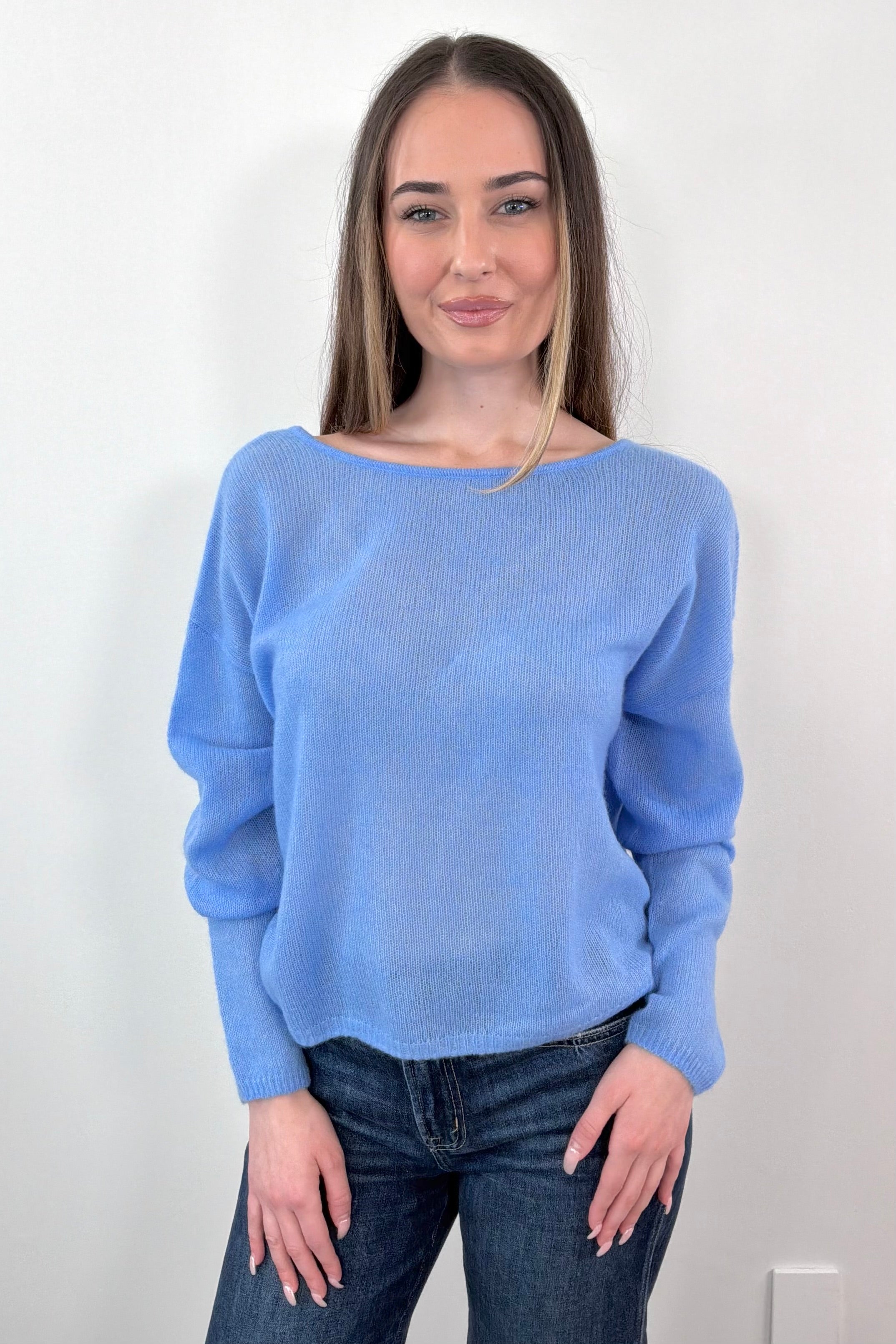 woman wearing blue cashmere sweater with a reversible neckline