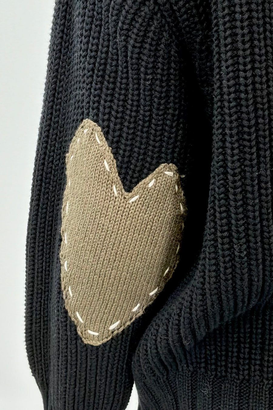 Woman wearing a black sweater with green heart patches
