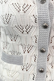 Close-up of a white 3/4 knitted button up cardigan 