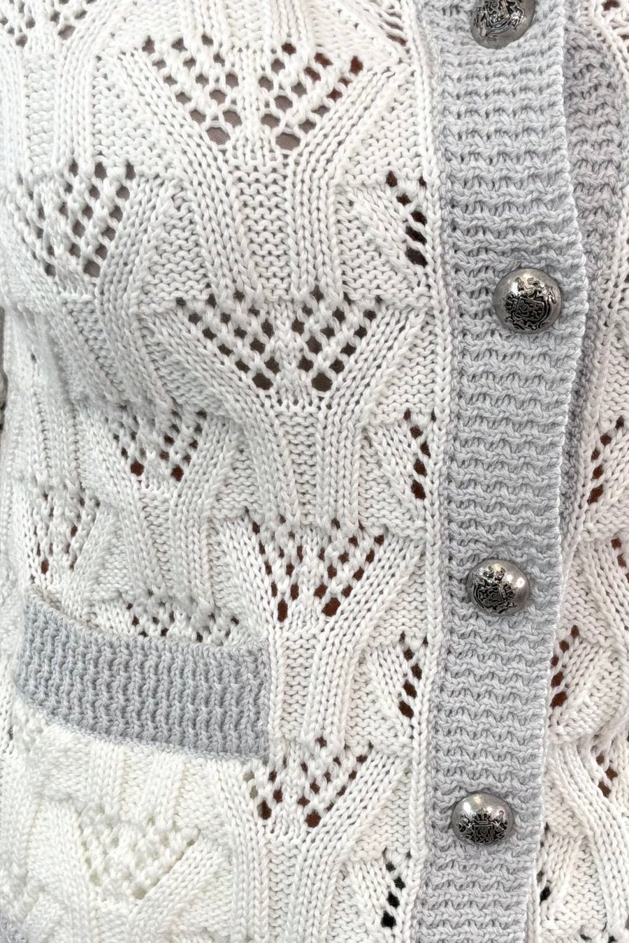 Close-up of a white 3/4 knitted button up cardigan 