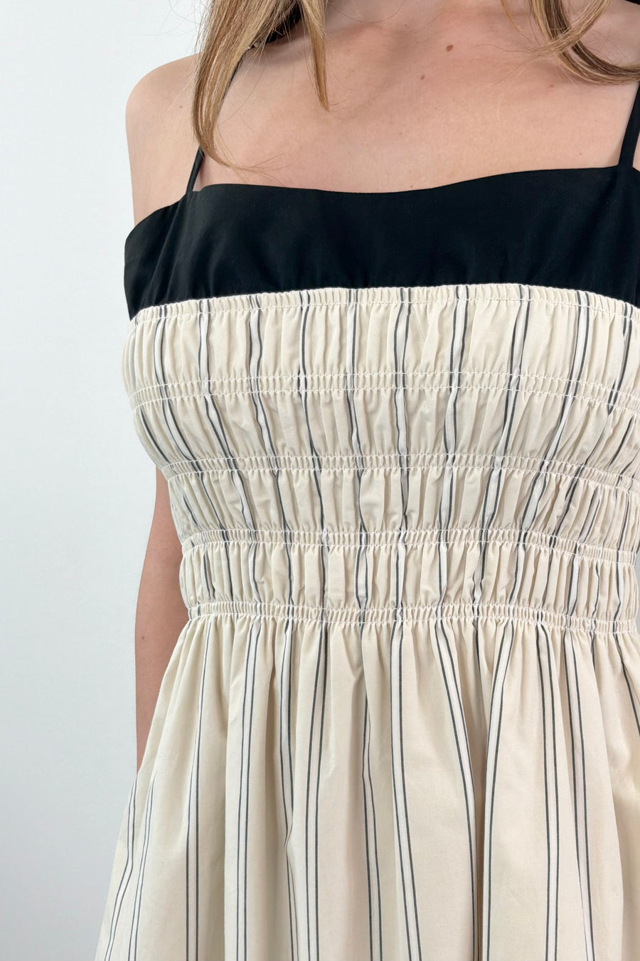 Close up of Woman wearing a layered striped dress in cream and black