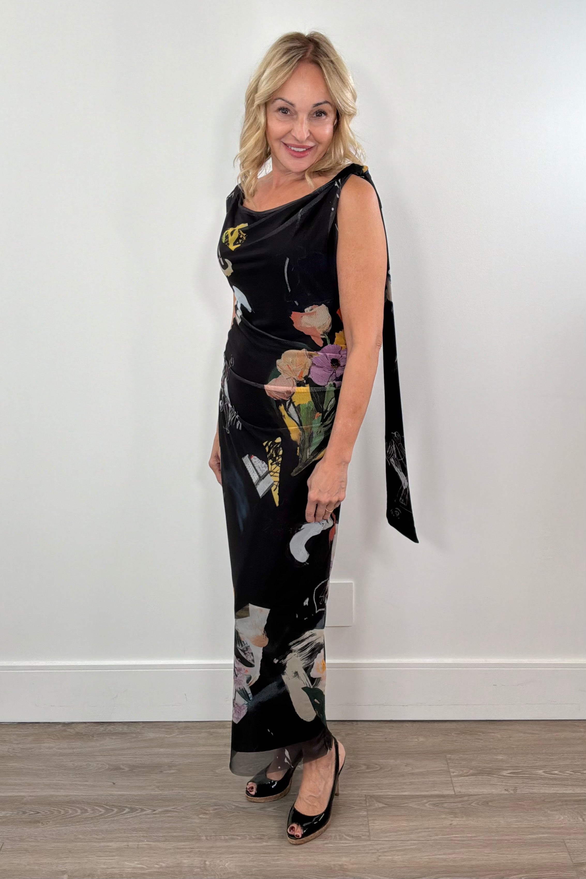 woman wearing a black maxi lined flower pattern mesh dress with detail in the strap