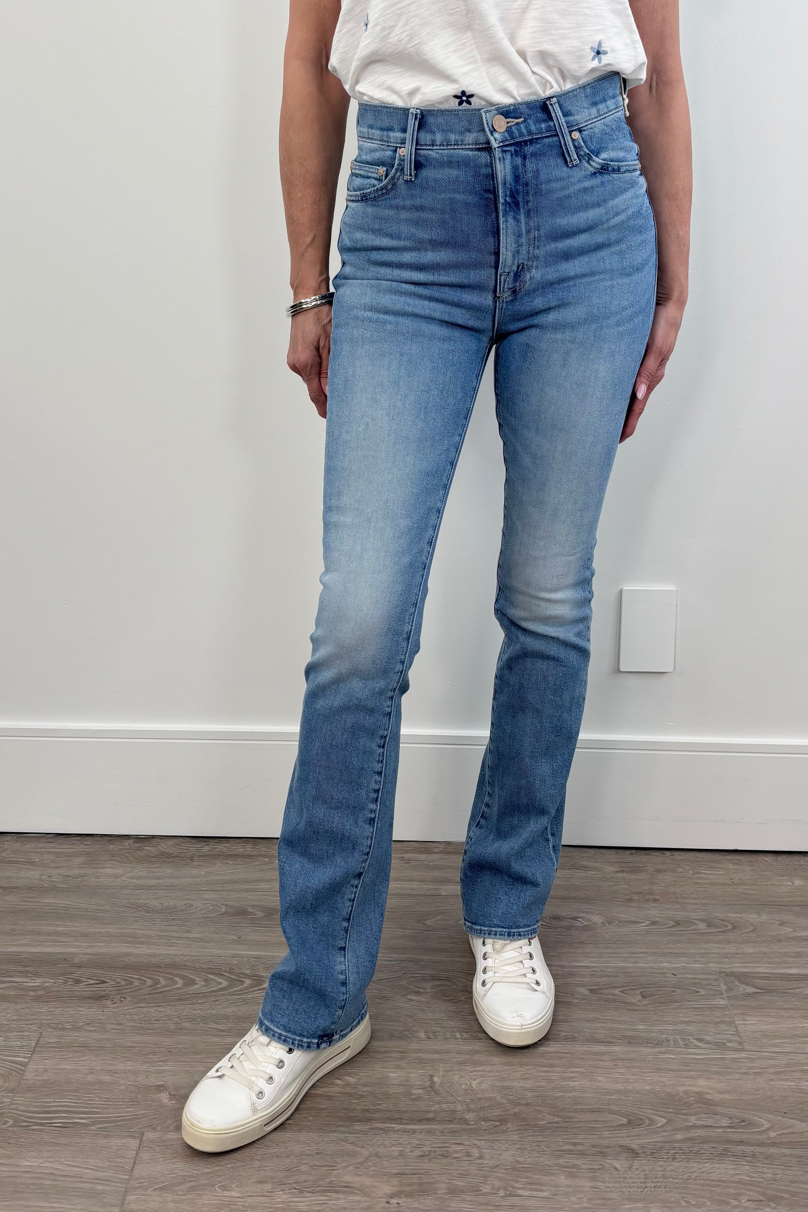 Woman wearing a mid blue wash slim bootcut pair of jeans