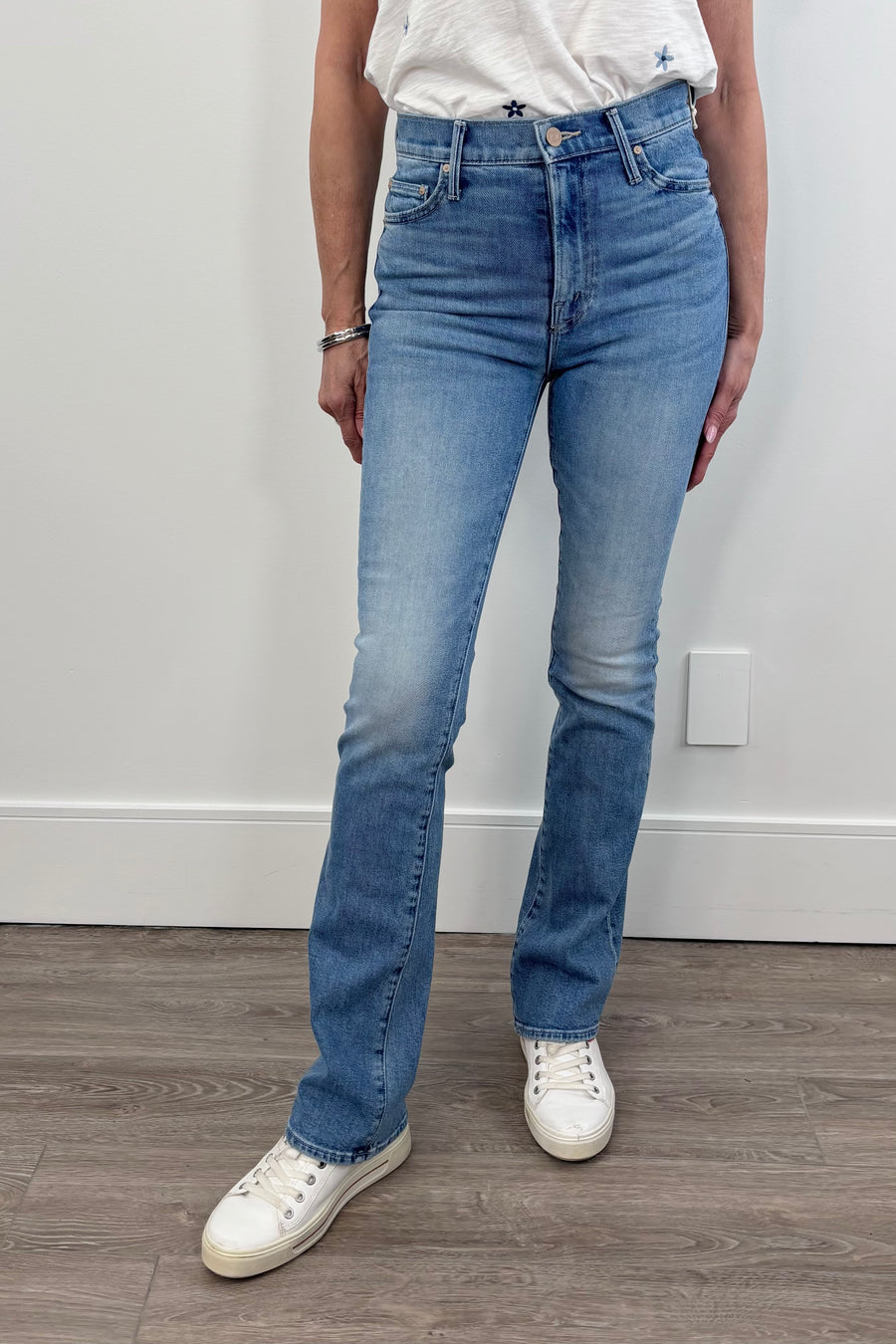 Woman wearing a mid blue wash slim bootcut pair of jeans