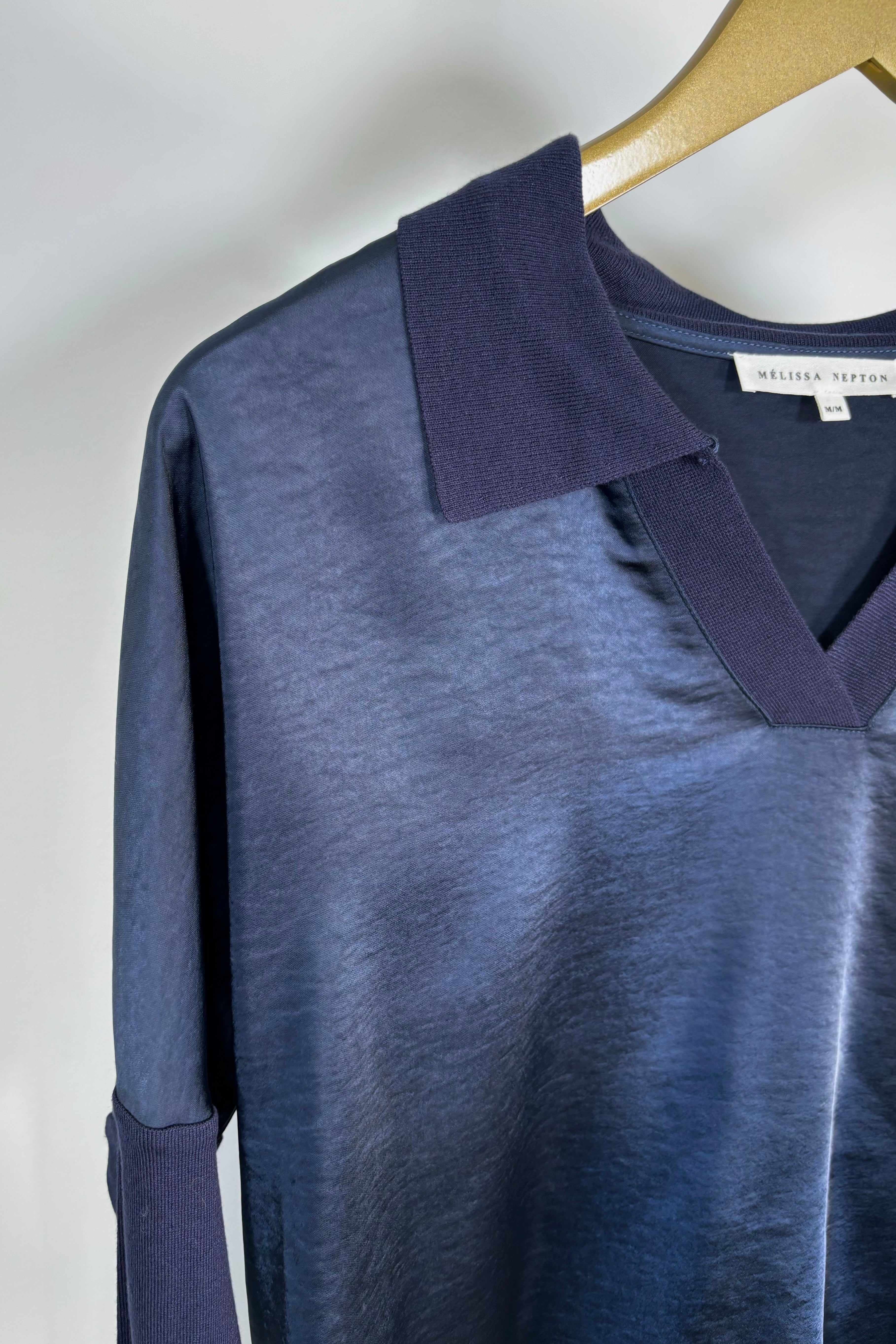 Close-up of the collar of a deep navy long sleeve v-neck top 