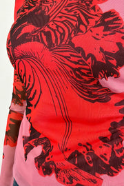 close-up of a pink bell sleeve mesh lined top with a red orchid print