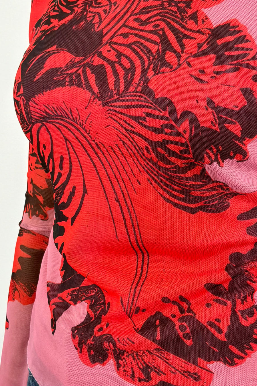 close-up of a pink bell sleeve mesh lined top with a red orchid print