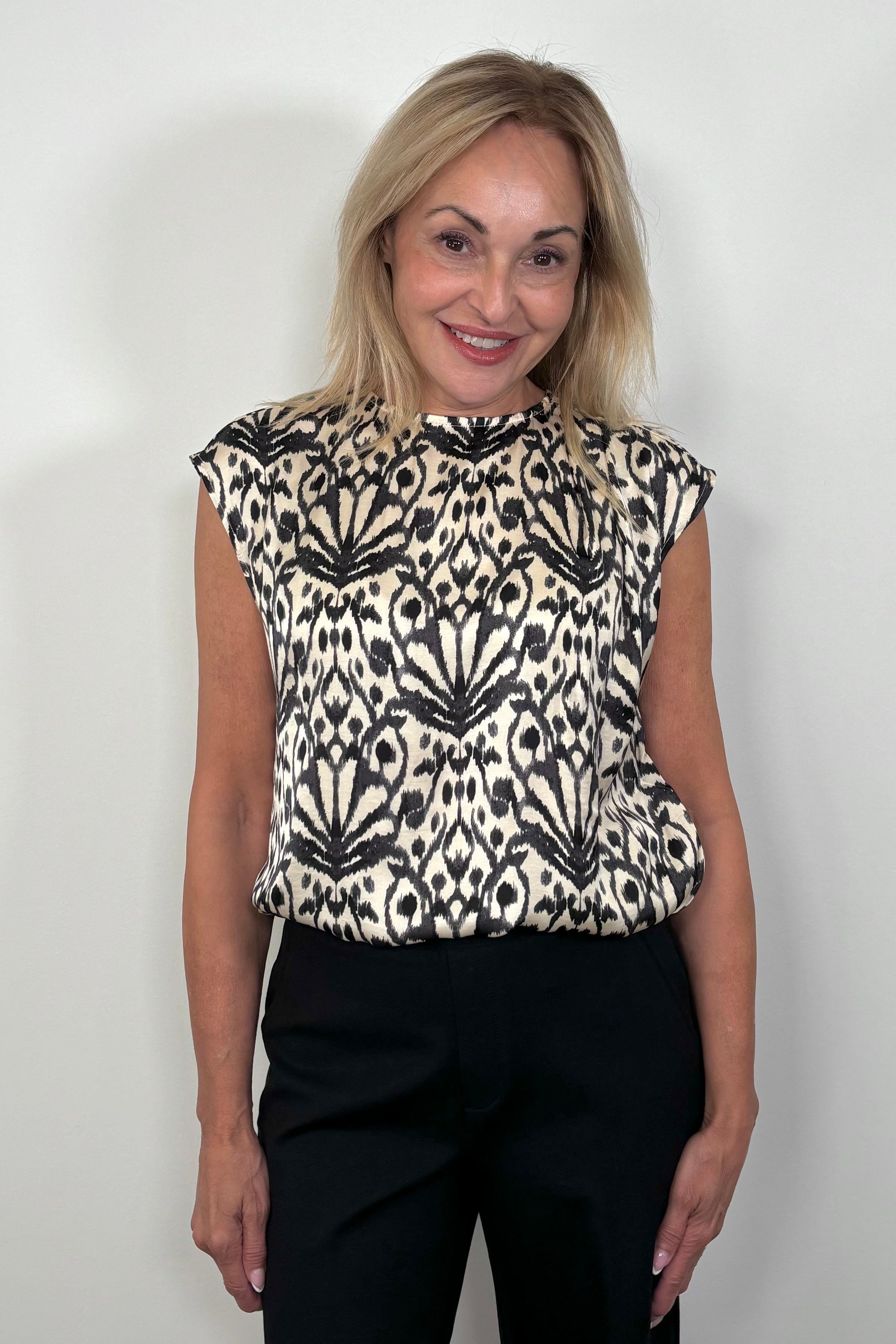 of woman wearing a printed Satin sleeveless top tucked in