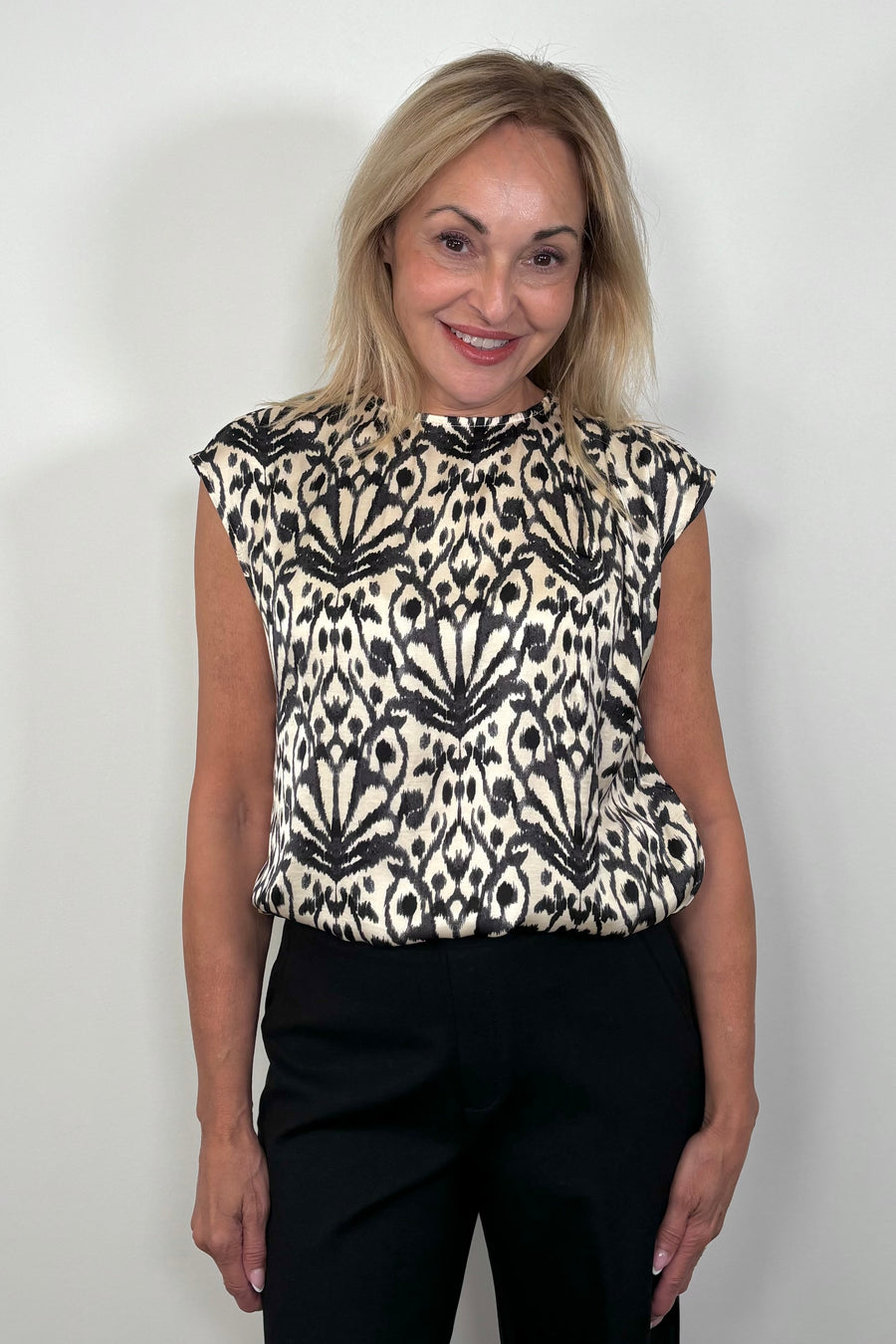 of woman wearing a printed Satin sleeveless top tucked in