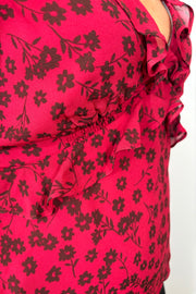 Close-up view of woman wearing a cool red chiffon top with a daisy pattern