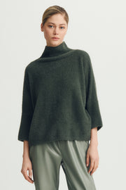 Woman wearing a green half sleeve hairy sweater
