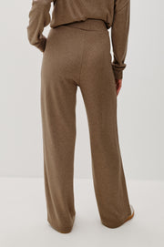 Back view of a person wearing brown pants on a white background 
