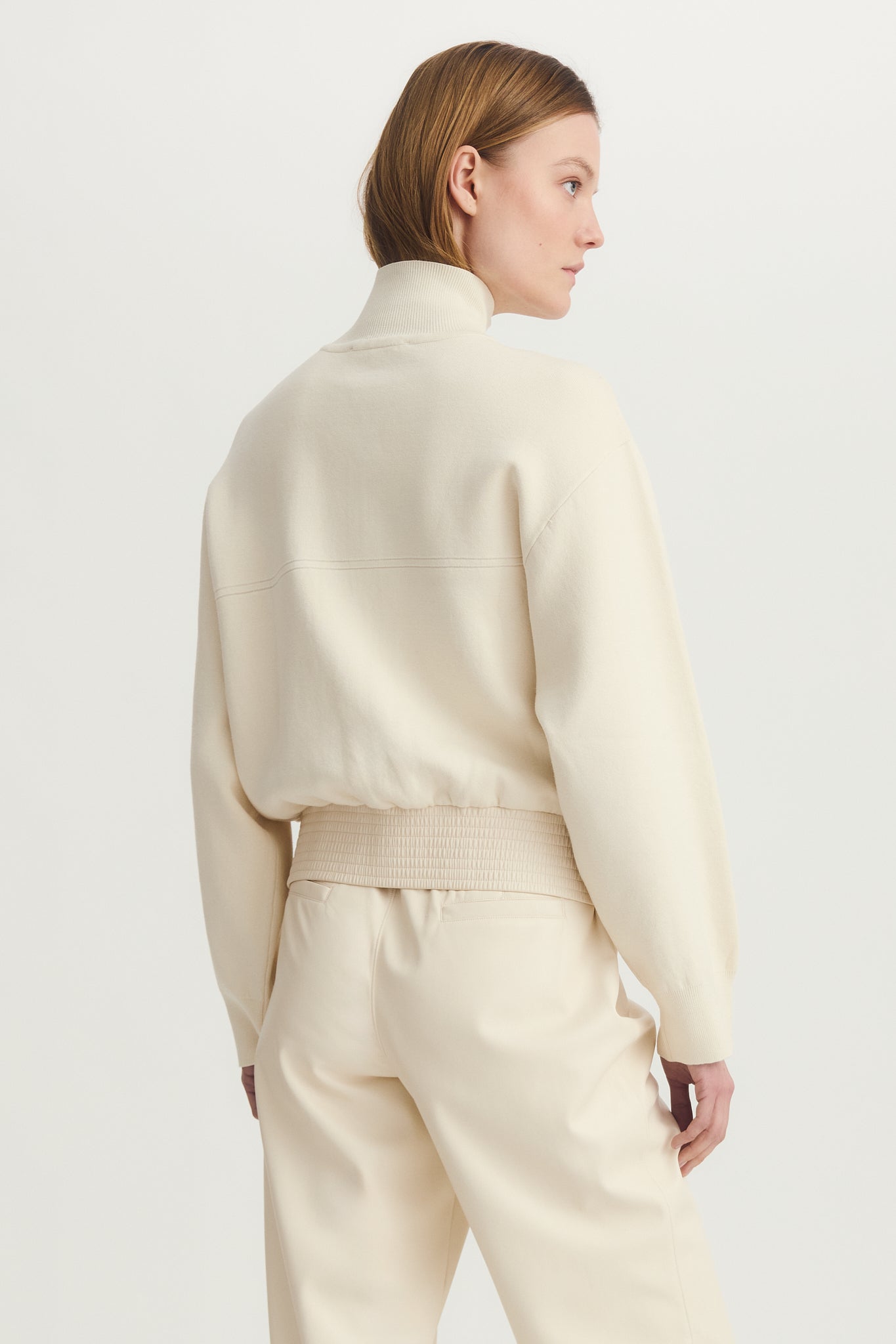 Back view of a woman wearing a nix media bomber jacket