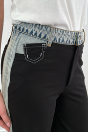 Close up of Woman wearing black dress pants with accents of light indigo denim