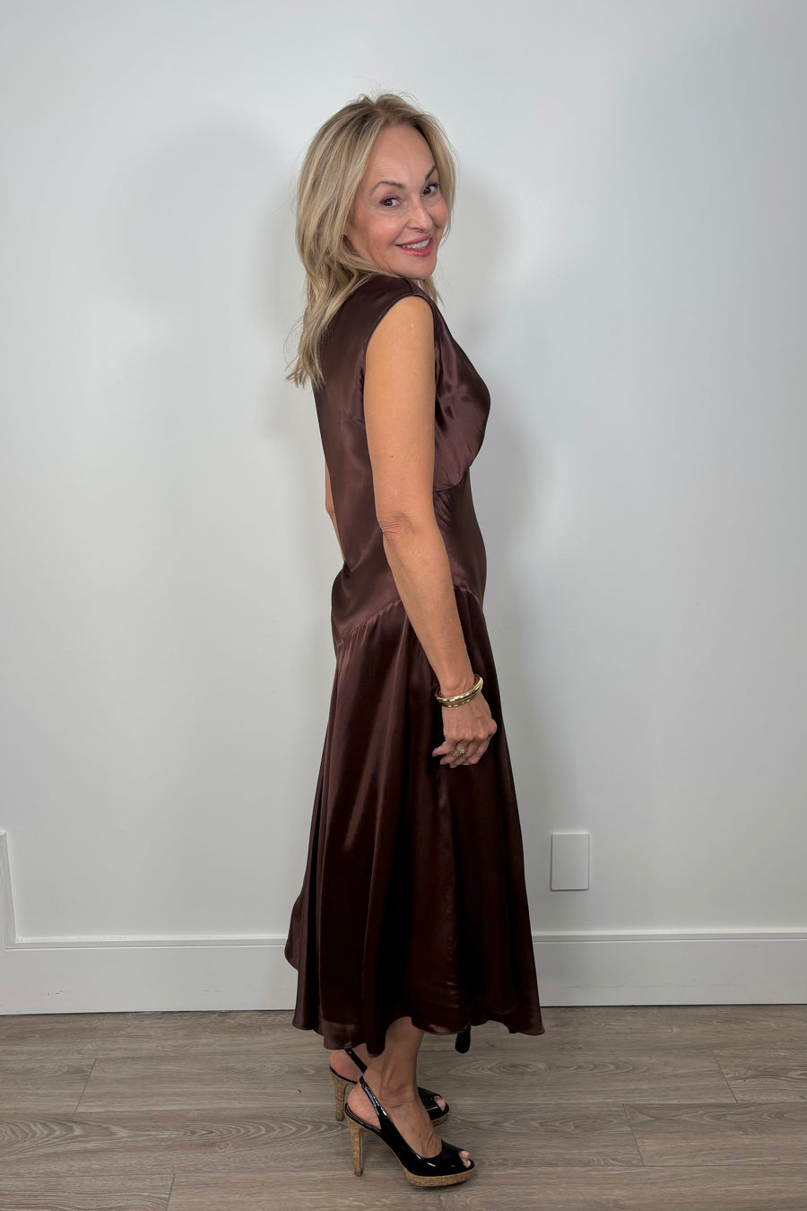side view of woman wearing a chocolate brown satin dress