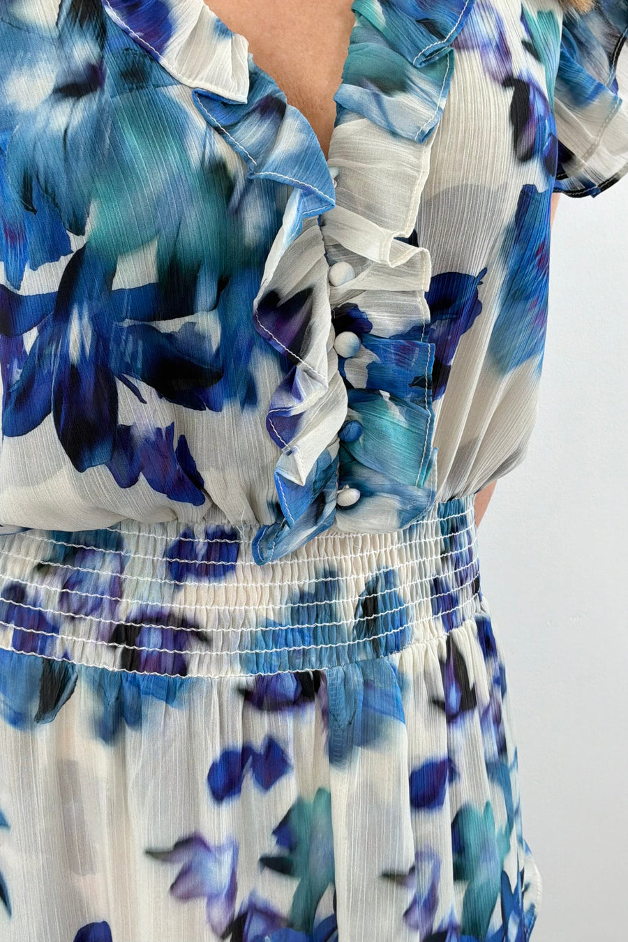 Close up of Woman wearing a blue floral print ruffle dress