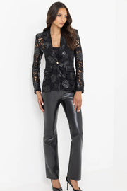 Full body image view of a woman wearing a black lace and leahter blazer and pants