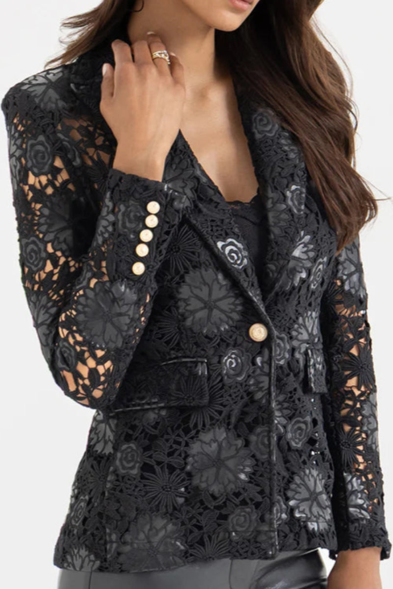 Close-up view of a woman wearing a black lace and leahter blazer