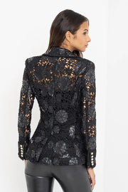 Back view of a woman wearing a black lace and leahter blazer