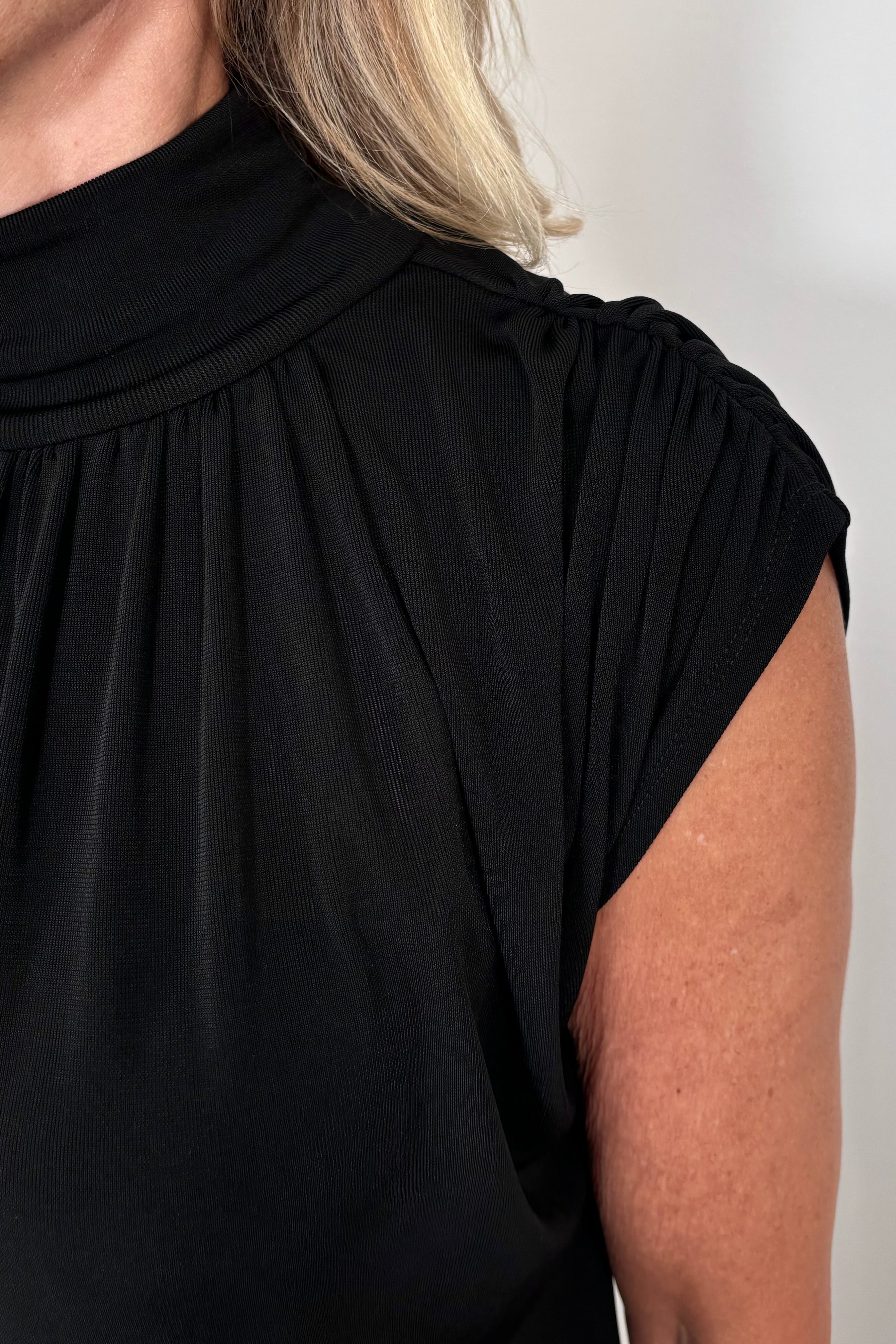 close-up of a woman wearing a black mock neck top