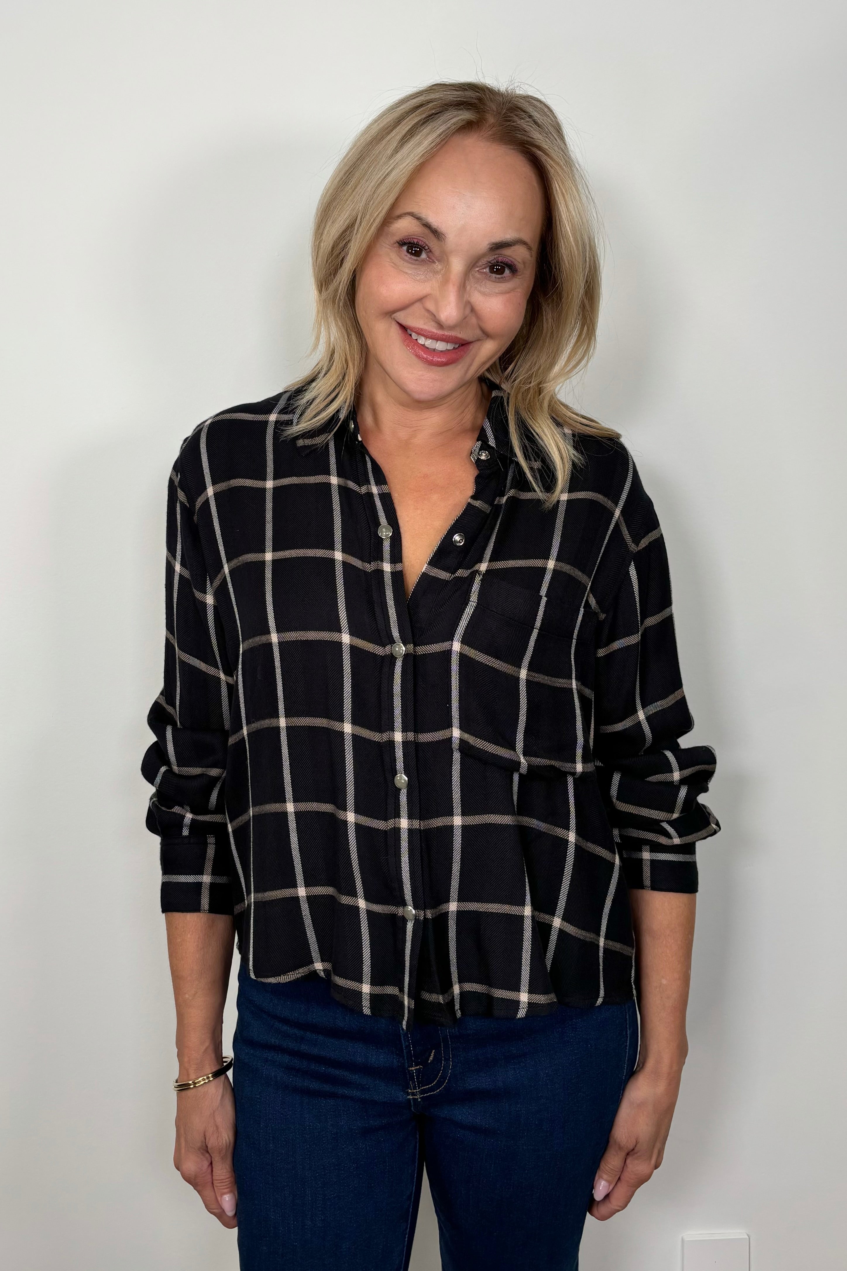 Front view of woman wearing  a black and white plaid shirt 