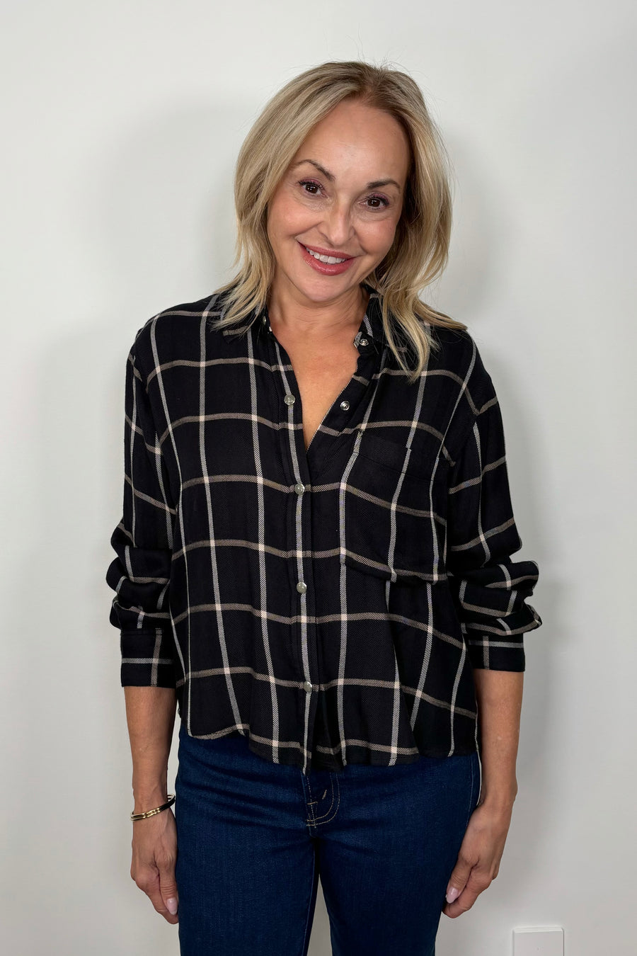 Front view of woman wearing  a black and white plaid shirt 