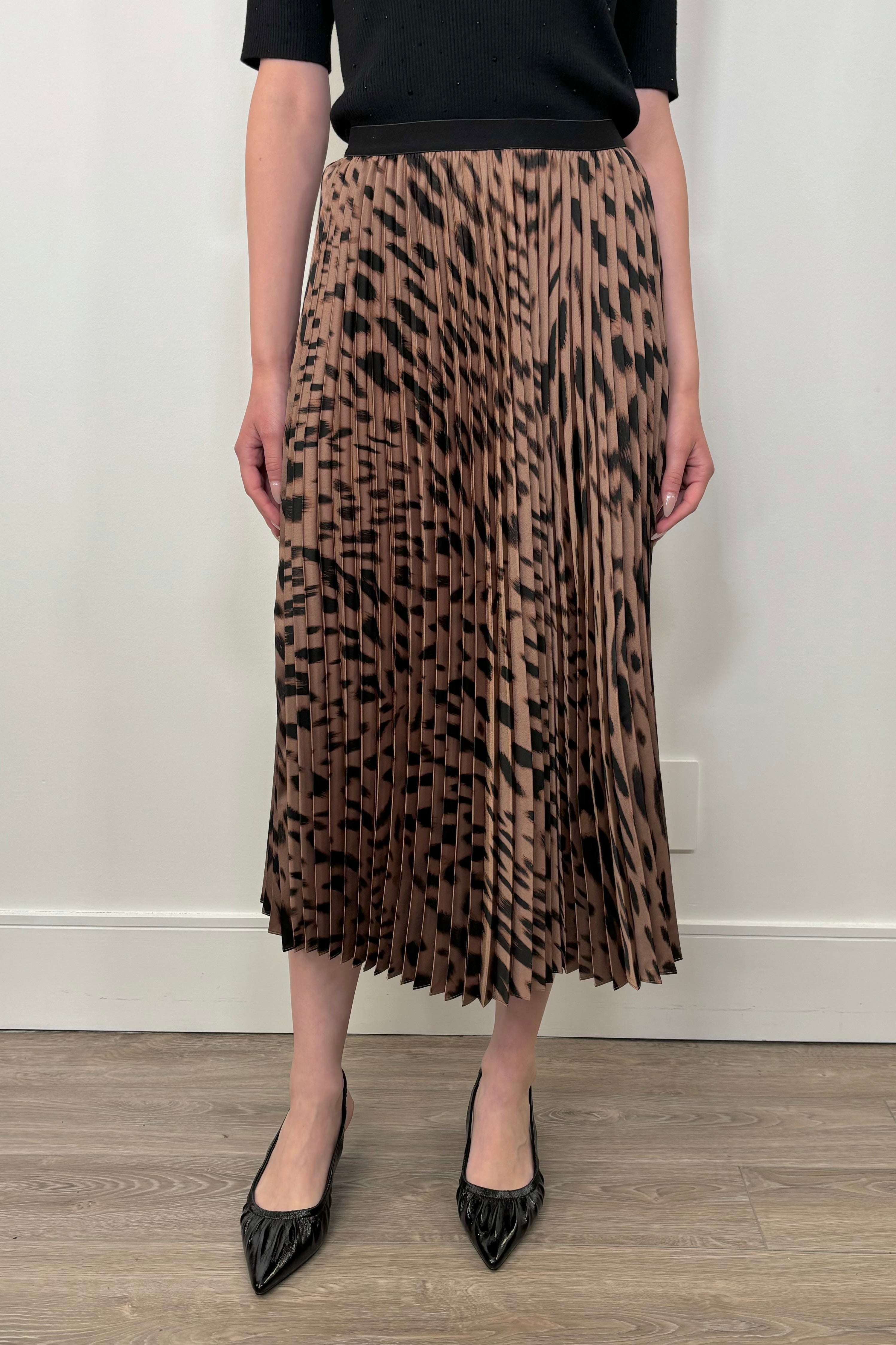 Front view of a woman wearing a leopard printed midi skirt 