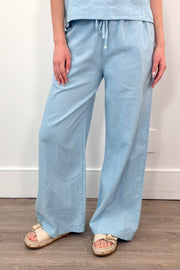 Woman wearing light blue wide leg linen pants with a drawstring waistband