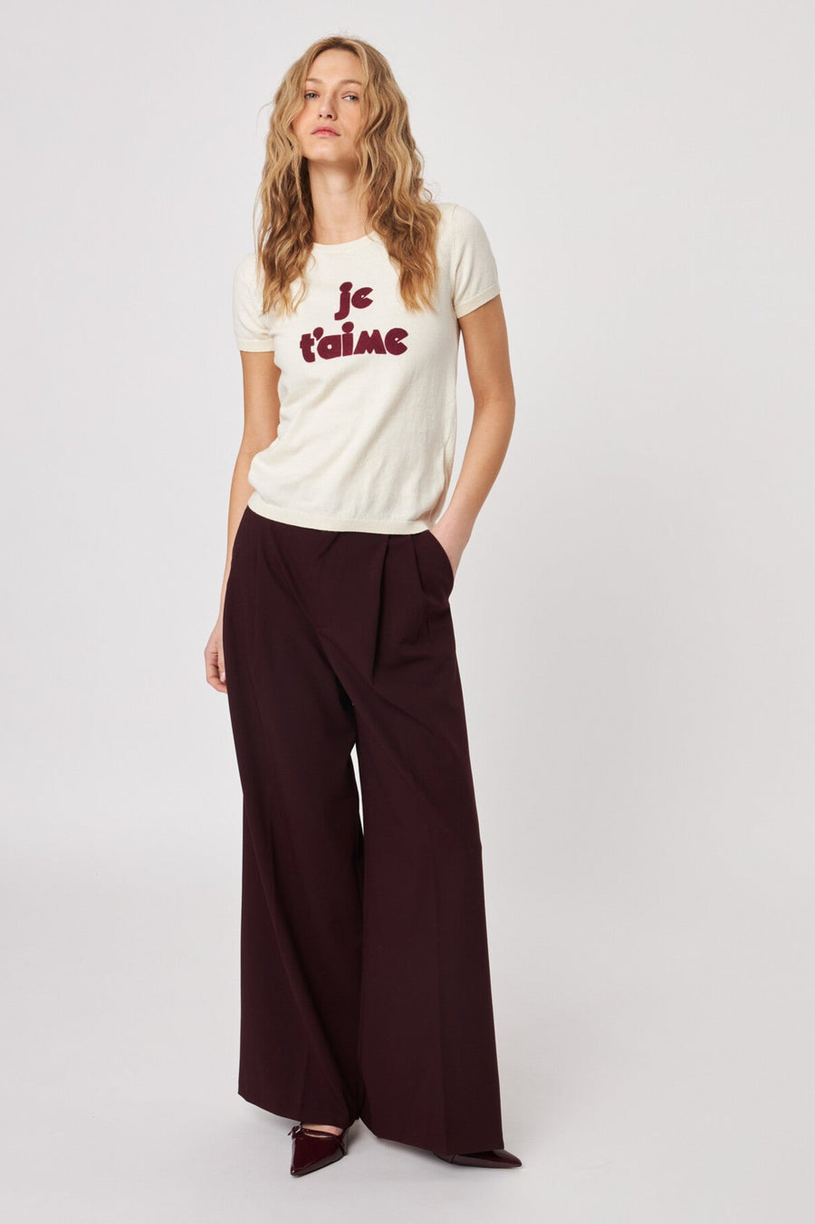 Front view of woman wearing a knitted tee shirt with text on it