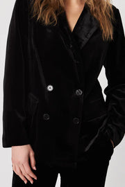 Woman wearing a black blazer and pants against a white background