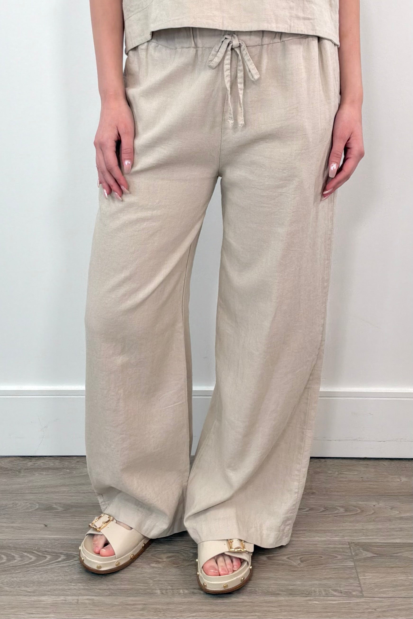 Woman wearing wide leg, cotton, twill pant in sand