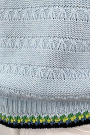 Close-up of a light blue knitted tank with black and green stitching
