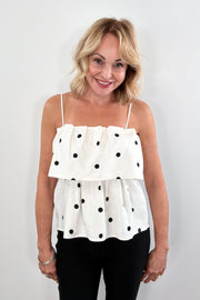 Woman wearing a lightweight linen-viscose white top with black polka dots 