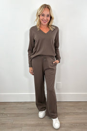 Woman wearing a brown v-neck pull on sweat top and a matching drawstring pant