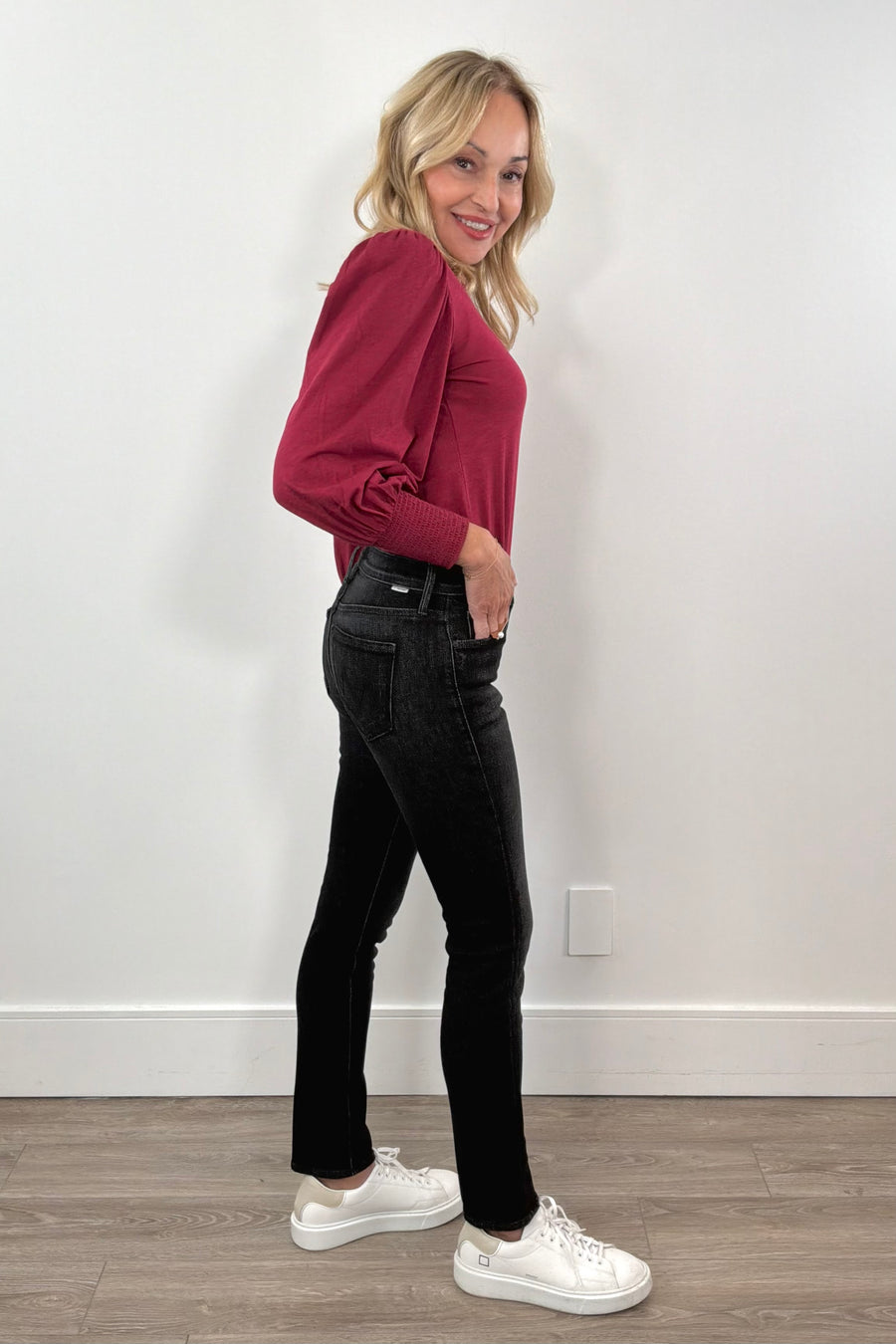 woman wearing washed black fitted jeans and a red top