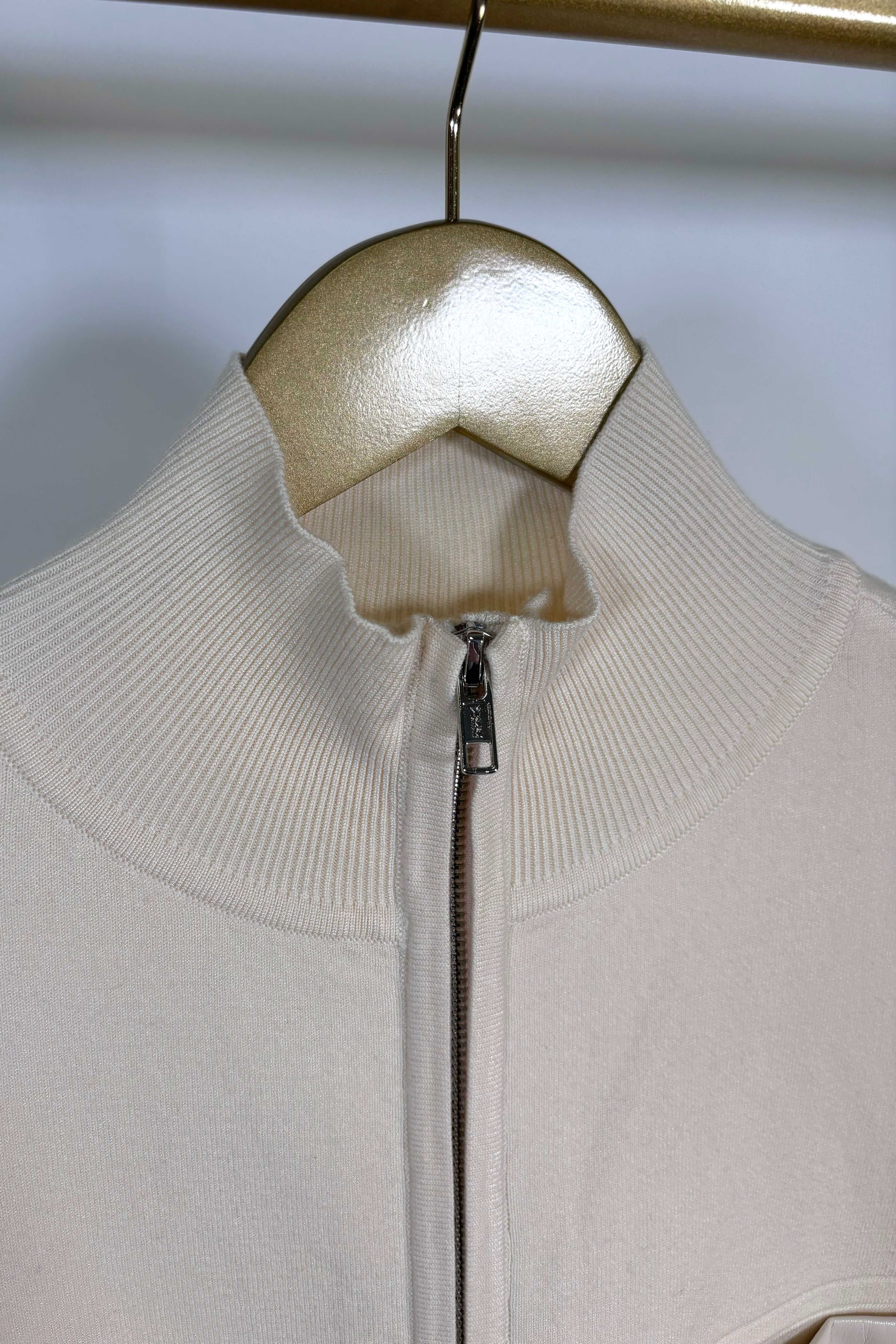 Close-up of the collar of a cream coloured mix media bomber jacket 