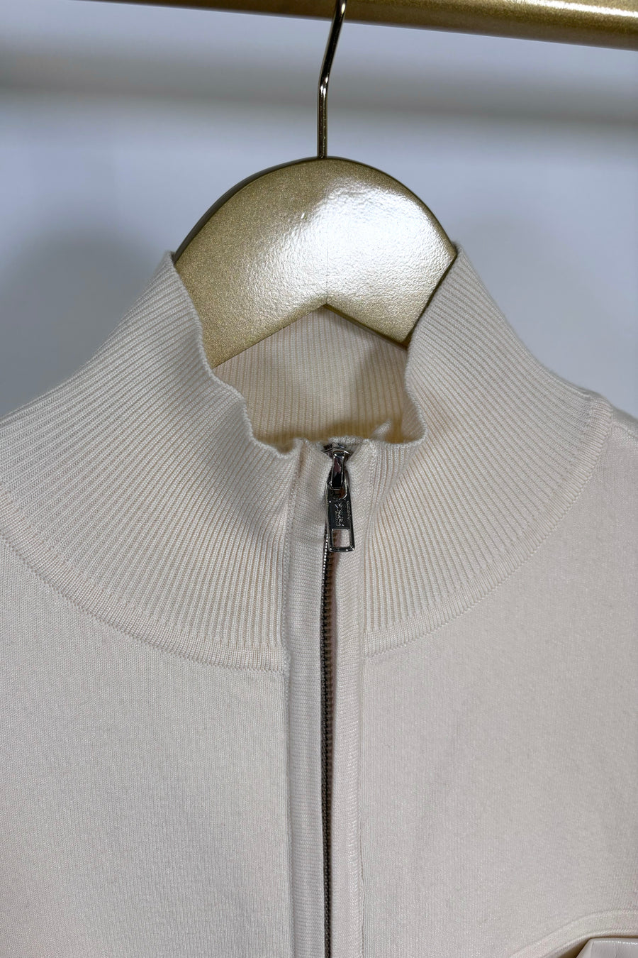 Close-up of the collar of a cream coloured mix media bomber jacket 