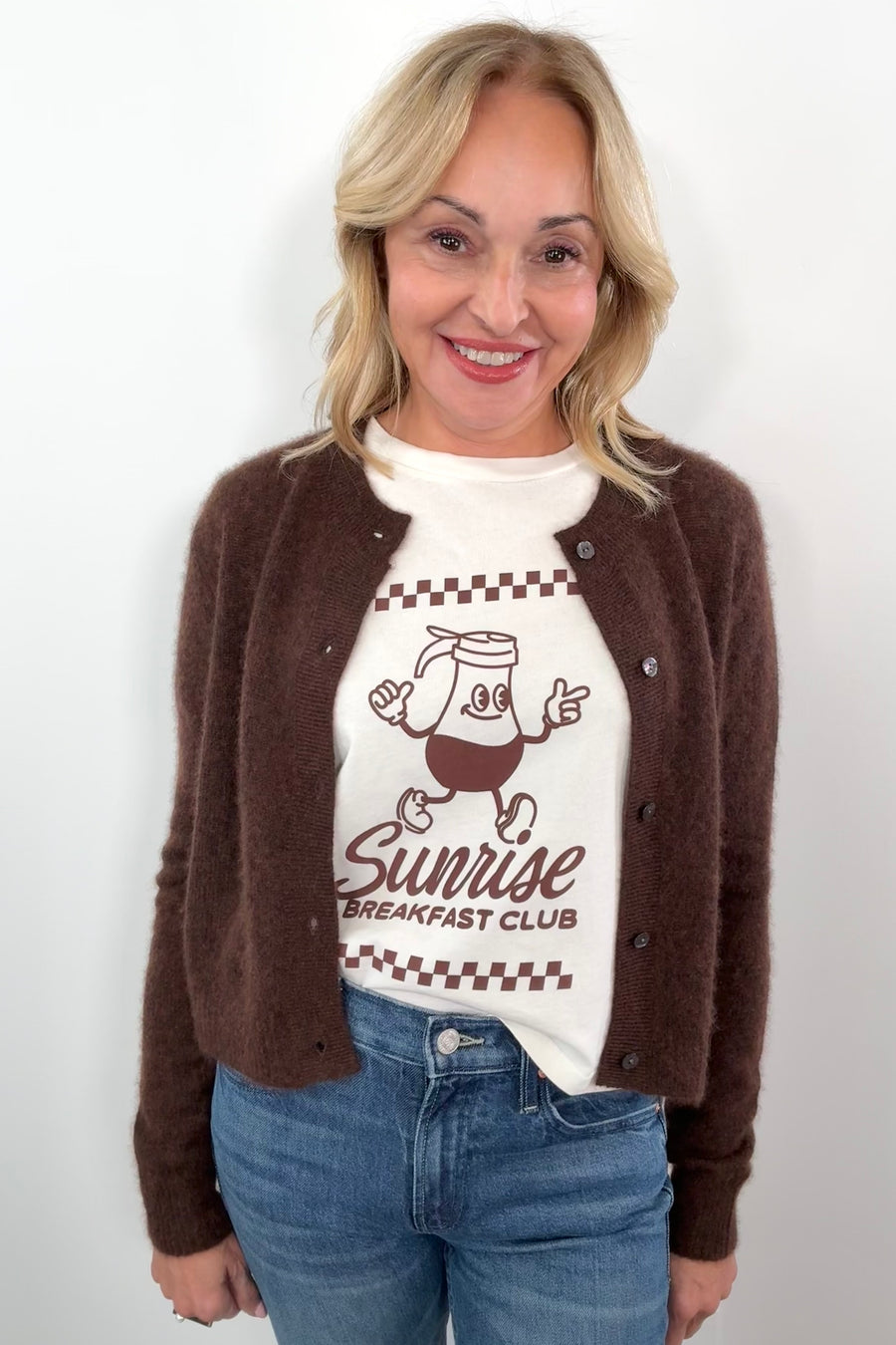 woman wearing a white tee with a brown maple syrup graphic with a brown cardigan