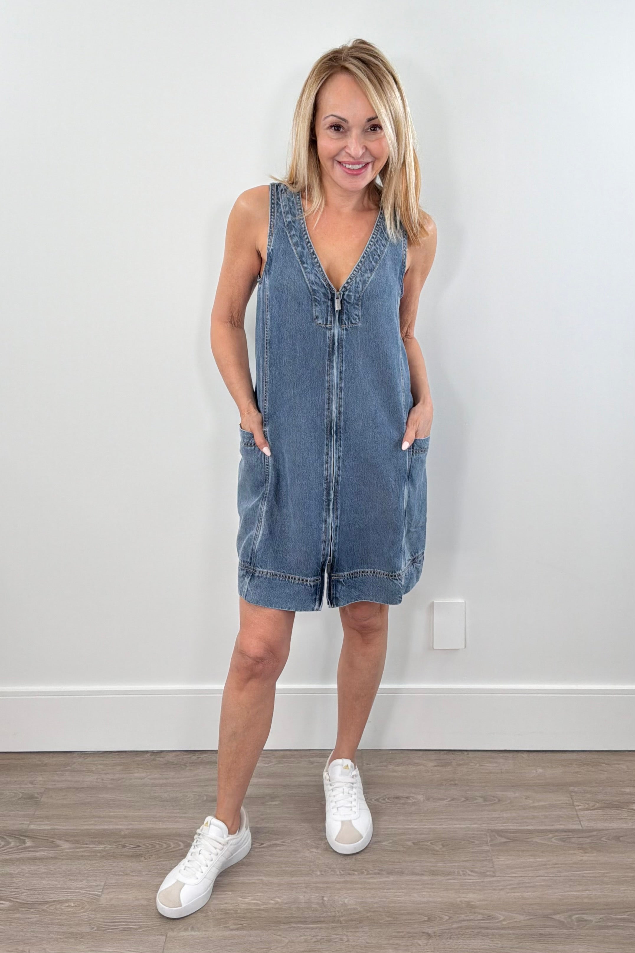 Sleeveless light wash denim mini dress with a V-neck and front seam detail, front view
