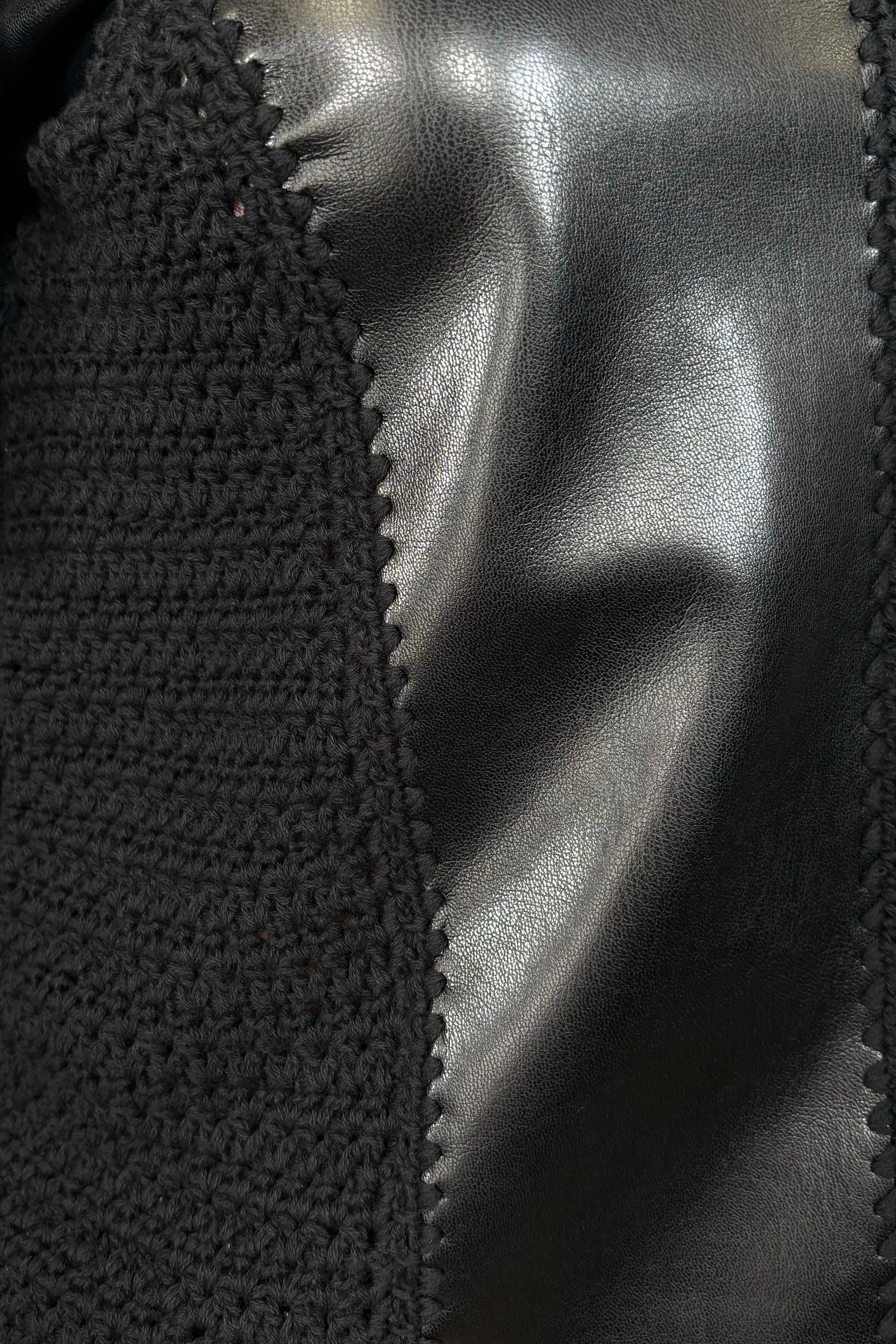 Close-up of a black mix leather and crochet tee