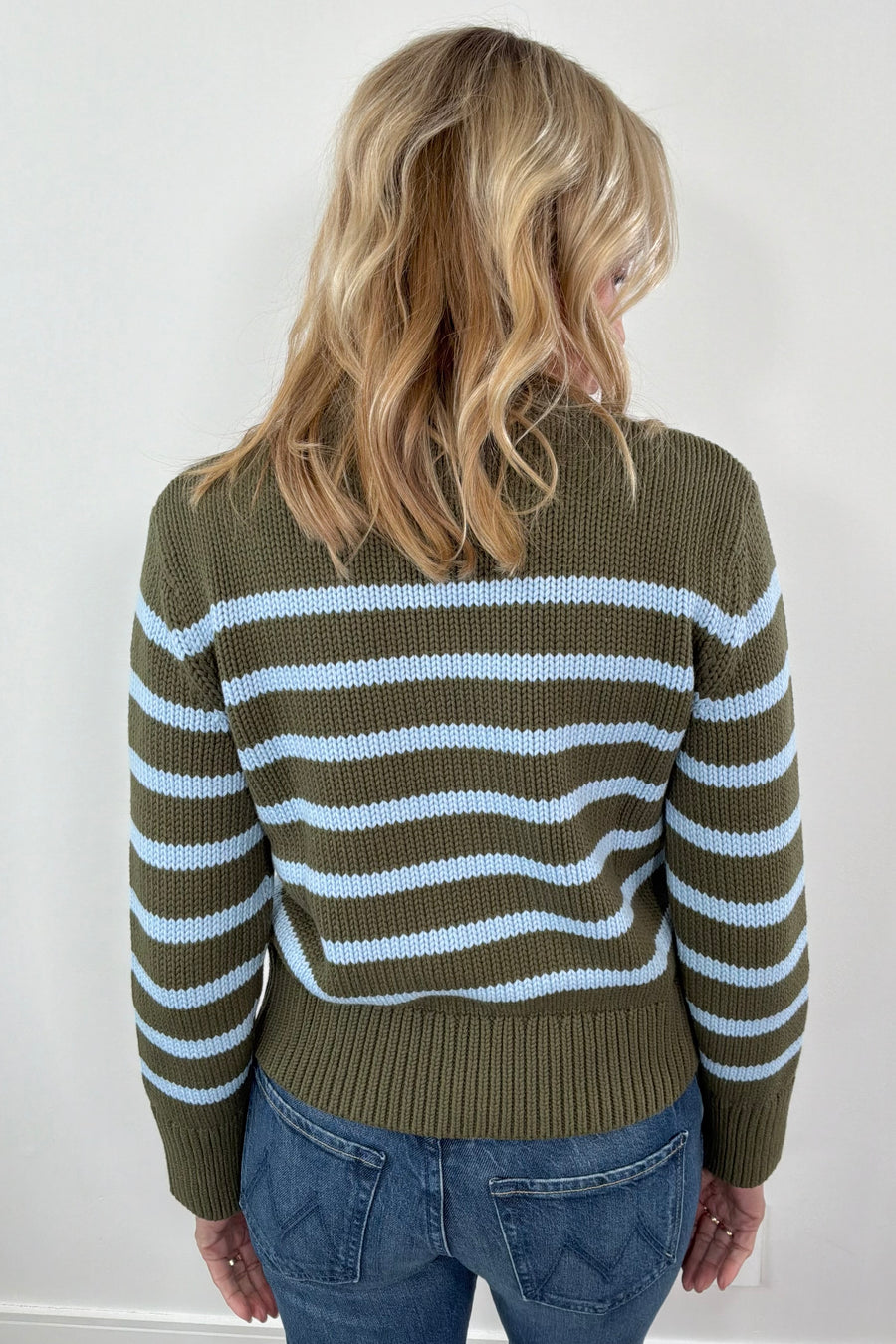Woman wearing a green and blue striped sweater 