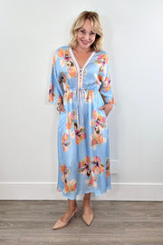 Woman wearing a light blue floral kimono dress with tie around the waist 